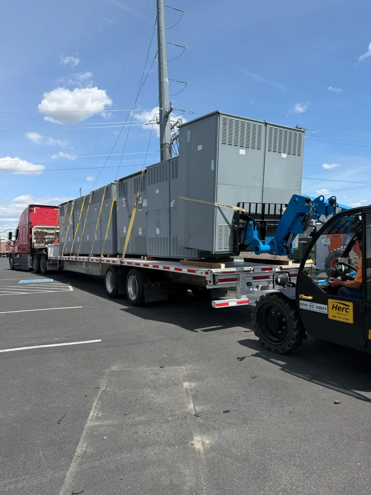 Switchgear sections loaded on a flatbed with a telehandler — Cape Coral, FL